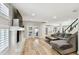 Open living room with a fireplace, gray sectional, wood floors, and entry to the kitchen at 4203 W Cleveland St, Tampa, FL 33609