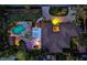 Aerial night view of a home with a lush backyard oasis, featuring a pool, outdoor bar, and landscaped grounds at 4301 S Lockwood Ridge Rd, Sarasota, FL 34231