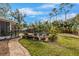 Lush backyard with brick pavers leading to a sparkling pool, inviting lounge area, and tropical landscaping at 4301 S Lockwood Ridge Rd, Sarasota, FL 34231