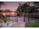 Private fenced backyard with brick patio, lush landscaping, and exterior lighting at 4301 S Lockwood Ridge Rd, Sarasota, FL 34231