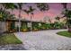 Charming single-story home with lush, green vine-covered facade and paver driveway surrounded by mature landscaping at 4301 S Lockwood Ridge Rd, Sarasota, FL 34231