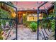 Inviting front entrance with a wrought-iron gate, ivy-covered exterior, and a quaint, tiled entryway to 