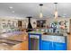 Kitchen island with sink and dishwasher, open to dining area with decorative hanging lights at 4301 S Lockwood Ridge Rd, Sarasota, FL 34231