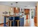 Stylish kitchen boasts pendant lighting, a modern island, and hardwood floors throughout at 4301 S Lockwood Ridge Rd, Sarasota, FL 34231