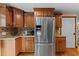 Kitchen featuring stainless steel refrigerator, wood cabinets, and granite countertops at 4301 S Lockwood Ridge Rd, Sarasota, FL 34231