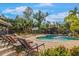 Resort-style pool area with sun loungers, a tiki bar, and lush landscaping for ultimate relaxation at 4301 S Lockwood Ridge Rd, Sarasota, FL 34231