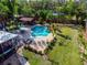 Aerial view of a backyard featuring a freeform pool, waterfall feature, outdoor kitchen, and lush landscaping at 4301 S Lockwood Ridge Rd, Sarasota, FL 34231