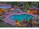 Aerial view of a backyard pool with surrounding patio, outdoor bar, lush landscaping, and poolside lounge area at 4301 S Lockwood Ridge Rd, Sarasota, FL 34231