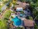 Aerial view of a backyard featuring a kidney bean pool, covered patio, lush landscaping, and privacy fence at 4301 S Lockwood Ridge Rd, Sarasota, FL 34231