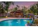 Backyard pool and tiki bar with dolphin water feature, offering a relaxing and entertaining outdoor space at 4301 S Lockwood Ridge Rd, Sarasota, FL 34231