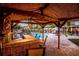 Outdoor tiki bar with seating, overlooking the pool and waterfall feature, perfect for entertaining and relaxing at 4301 S Lockwood Ridge Rd, Sarasota, FL 34231