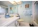 Well-lit bathroom with decorative wallpaper, framed mirror and shower with glass doors at 4550 Cove Cir # 1003, St Petersburg, FL 33708
