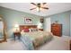 Cozy bedroom with a floral quilt, ceiling fan, and complementary lamps at 4550 Cove Cir # 1003, St Petersburg, FL 33708