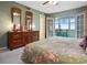 Comfortable bedroom featuring balcony access with seating, floral bedding, and neutral walls at 4550 Cove Cir # 1003, St Petersburg, FL 33708