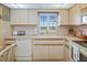 Bright kitchen with white cabinets, tile backsplash, and a window offering a view at 4550 Cove Cir # 1003, St Petersburg, FL 33708