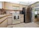 Functional kitchen featuring appliances, light wood cabinets, and tile floors at 4550 Cove Cir # 1003, St Petersburg, FL 33708