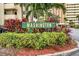 A lushly landscaped sign reads 