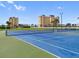 Well-maintained tennis courts ready for a match, set against a backdrop of beautiful buildings at 4550 Cove Cir # 1003, St Petersburg, FL 33708