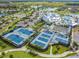 Aerial view of community tennis courts and clubhouse with surrounding landscaping at 4620 Ballast Crest Cv, Land O Lakes, FL 34638