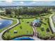Aerial view of community dog park and walking path with trees and blue shade shelter at 4620 Ballast Crest Cv, Land O Lakes, FL 34638