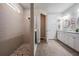 Bathroom featuring a large shower, double sink vanity, tile floors, framed mirrors, and modern fixtures at 4620 Ballast Crest Cv, Land O Lakes, FL 34638
