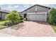 Stunning exterior view showcasing brick driveway, grey paint, and immaculate landscaping at 4620 Ballast Crest Cv, Land O Lakes, FL 34638