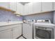Laundry room with modern washer, dryer, cabinets, countertop, and sink at 4620 Ballast Crest Cv, Land O Lakes, FL 34638