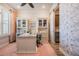 Cozy office space featuring built-in cabinets, a modern desk, and charming wallpaper accent at 4620 Ballast Crest Cv, Land O Lakes, FL 34638