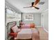 Charming bedroom with two beds, wood-look floors, a ceiling fan, and windows with decorative vines at 504 7Th Sw Ave, Largo, FL 33770