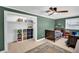 Bedroom with green walls, wood floors, a ceiling fan, and built-in shelving, ideal for  at 504 7Th Sw Ave, Largo, FL 33770