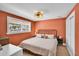 Bedroom featuring a black metal bed frame, a window for natural light, and vibrant orange walls at 504 7Th Sw Ave, Largo, FL 33770