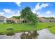 Backyard featuring mature tree providing shade, lush green lawn with pond creating peaceful view at 5525 Turtle Crossing Loop, Tampa, FL 33625