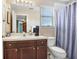 Bathroom with a wooden vanity, single sink, and a framed mirror at 5525 Turtle Crossing Loop, Tampa, FL 33625