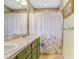 Green bathroom with tile flooring, shower tub combo, and a vanity offers comfort and function at 5525 Turtle Crossing Loop, Tampa, FL 33625