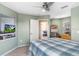 Bedroom features a ceiling fan, built-in shelving, and a view into the living room at 5525 Turtle Crossing Loop, Tampa, FL 33625