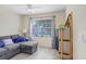 Comfortable bedroom with a gray sofa, large window, and neutral tones at 5525 Turtle Crossing Loop, Tampa, FL 33625