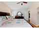 Bedroom with wood flooring, ceiling fan, and a dark dresser offers comfort in this lovely home at 5525 Turtle Crossing Loop, Tampa, FL 33625