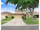 Charming two-story home with a spacious driveway and lush front yard, partially shaded by a mature tree at 5525 Turtle Crossing Loop, Tampa, FL 33625