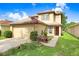 Inviting two-story home featuring a well-manicured lawn, attached garage and patriotic American flag at 5525 Turtle Crossing Loop, Tampa, FL 33625