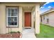 Close-up of a welcoming front entrance with a solid door and adjacent window allowing natural light at 5525 Turtle Crossing Loop, Tampa, FL 33625
