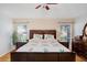 Comfortable main bedroom featuring a ceiling fan, dark wood furniture and natural light at 5525 Turtle Crossing Loop, Tampa, FL 33625