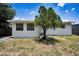 View of backyard highlighting the mature shade tree and white siding, set on a grassy lot at 5642 9Th N Ave, St Petersburg, FL 33710