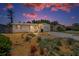 Charming single-story home at twilight with an inviting front yard and private driveway at 5642 9Th N Ave, St Petersburg, FL 33710