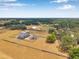 Breathtaking aerial view of a home with solar panels, pool, circular drive, and a lush yard surrounded by towering trees at 602 Swilley Rd, Plant City, FL 33567