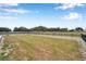 Large grassy fenced backyard with trees and a building in the background at 602 Swilley Rd, Plant City, FL 33567