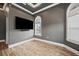 Bedroom featuring a large TV, wood-look floors, and arched windows at 602 Swilley Rd, Plant City, FL 33567