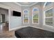 Bright bedroom featuring hardwood floors, TV, and large arched windows at 602 Swilley Rd, Plant City, FL 33567