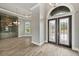 Elegant foyer featuring wood-look tile floors, decorative chandeliers, and a glass-enclosed room for refined living at 602 Swilley Rd, Plant City, FL 33567