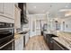 Stylish kitchen featuring gray cabinets, stainless steel appliances, and a striking black range hood at 602 Swilley Rd, Plant City, FL 33567