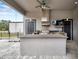 Covered outdoor kitchen featuring a grill, bar area, and television at 602 Swilley Rd, Plant City, FL 33567